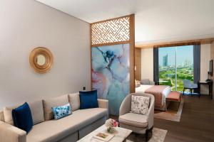 迪拜Taj Jumeirah Lakes Towers的客厅配有沙发和1张床