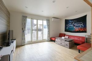 宜兰市乘風之旅溫馨包層華廈每日只接待一組客人最多6人的客厅配有红色沙发和电视