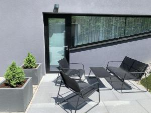 鲁容贝罗克Chalet - Apartmán Malinô HRABOVO的庭院里摆放着一组椅子和一张桌子