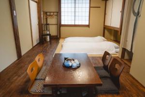 京都京之宿三源二年坂日式旅馆的配有桌椅和床的房间
