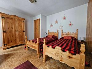 托尔诺Appartamento panoramico La Chapelle的一间卧室设有两张木床和木柜