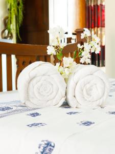 清莱AIRBEST Explore Chiang Rai Hotel的两卷毛巾放在带鲜花的桌子上