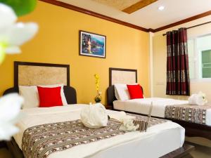 清莱AIRBEST Explore Chiang Rai Hotel的黄色墙壁客房的两张床