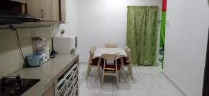 古来Homestay Merbau Bandar Putra Kulai的厨房配有桌椅和冰箱。