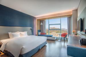 泰安泰安中心智选假日酒店的酒店客房设有一张大床和一张书桌。