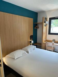 热姆诺B&B HOTEL Aubagne Gémenos的卧室配有一张白色大床和一张书桌