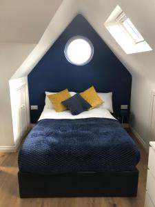 剑桥Cosy Loft Apartment Just Off Vibrant Mill Rd Cb1的蓝色卧室配有带黄色枕头的床