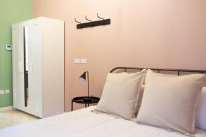 科斯皮夸Three Cities Guest House的一间卧室配有一张带白色枕头和镜子的床
