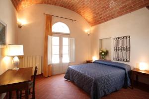 帕拉伊阿Agriturismo Podere La Casa的一间卧室配有一张床、一张书桌和一个窗户。