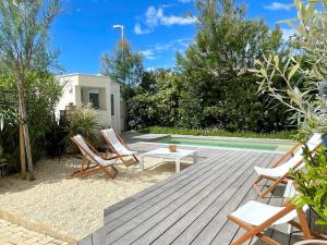 拉格朗德默特La Villa Bord de Mer N02的一个带桌椅的庭院和一个游泳池