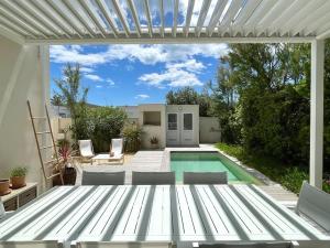 拉格朗德默特La Villa Bord de Mer N02的一个带白色凉棚和游泳池的庭院