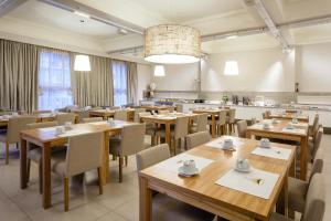 马德普拉塔法康德尔马酒店的用餐室配有木桌和椅子