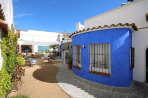 滨海圣波尔B&B Sant Pol - Adults Only的蓝色和白色的建筑,设有庭院