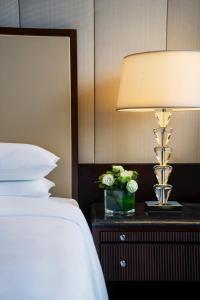 重庆重庆JW万豪酒店的一间卧室配有一张床和一张桌子上的台灯