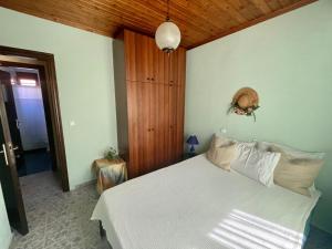 基尼拉Miro & Lana vacation home的卧室设有白色的床和木制天花板。