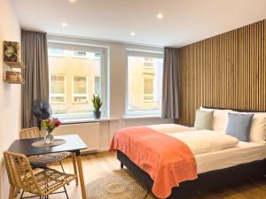 纽伦堡Lorenz Apartments的一间卧室配有一张床、一张桌子和一个窗户。