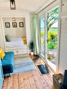 巴特尔The Green Hut的一间卧室设有一张床和一个滑动玻璃门