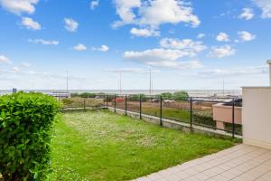 勒图凯-巴黎普拉日Modern flat with terrace and garden - Le Touquet - Welkeys的阳台享有草地和围栏美景。