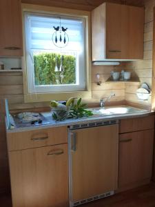 赛巴特班森Bungalow "Heimliche Liebe"的厨房设有水槽和窗户。