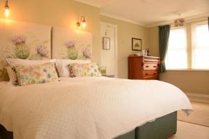 ScourieScourie Hotel的一间卧室配有一张白色大床,床上有鲜花