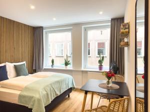 纽伦堡Lorenz Apartments的卧室配有床、桌子和窗户。