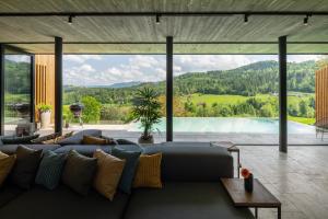 steiRerBLiCke - Weingartenresidenz Guntschenberg的带沙发和大窗户的客厅