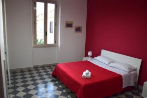 雷焦卡拉布里亚LYDOY APARTMENT的红色卧室配有一张带红色毯子的床