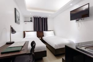 马尼拉Nest Nano Suites Poblacion - Makati的酒店客房配有两张床和一张书桌