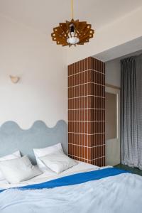 利托斯基简SOMTU design apartments的一间卧室配有一张带棕色瓷砖墙的床