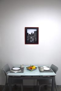雷焦卡拉布里亚LYDOY APARTMENT的一张桌子,上面有一盘水果和一张墙上的照片
