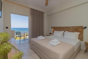 马拉松波利斯阿迪娜酒店的一间卧室配有一张床,享有海景
