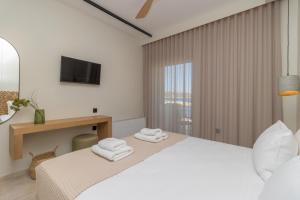 马拉松波利斯阿迪娜酒店的白色卧室,配有带毛巾的床