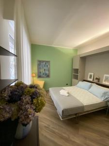 斯波托尔诺Strandhaus San Sebastiano的一间卧室设有一张床和绿色的墙壁