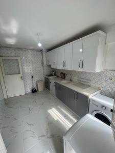 伯萨阿巴西公寓的厨房配有白色橱柜和白色瓷砖地板。