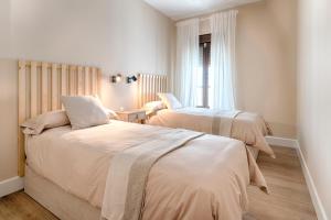 阿拉色那Apartamentos Turísticos Isems的一间卧室设有两张床和窗户。