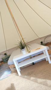 利马瓦迪Carrowmena Family Glamping Site & Activity Centre的帐篷里的一张床位,上面有植物