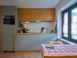 PiattaNew flat in Bormio - Centrale 69的一间厨房,内设白色橱柜和一张桌子