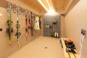费德拉帕加内拉Brenta Rosso - Charme Apartments的墙上设有滑雪板和滑雪设备的房间