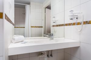 塔林迪曾格尔酒店的白色的浴室设有水槽和镜子