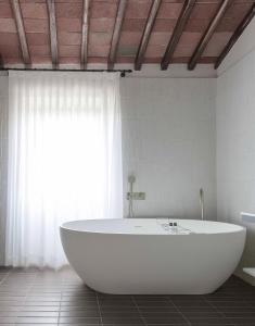 拉达-因基安蒂Pieve Aldina Relais & Châteaux的窗户客房内的白色浴缸