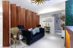 马尼拉NEST NANO SUITES POBLACION-MAKATI的客厅设有黑色沙发和木墙