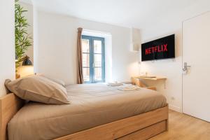 芒德Le Cocon - Netflix/Wifi Fibre - Séjour Lozère的墙上有标牌的房间的一张床位