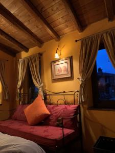 Palaioi PoroiIppoliti的一间卧室配有带粉红色枕头的床和窗户。