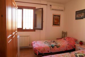 CantoriaVilla Soluna的一间小卧室,配有两张床和窗户