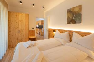 费德拉帕加内拉Brenta Rosso - Charme Apartments的卧室配有白色大床和白色枕头