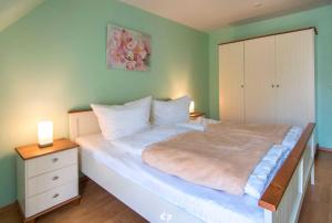 奥茨塞巴德·迪尔哈根SEESTERN App Nr 12 max 6 Pers的一间卧室配有一张大床、梳妆台和床头柜