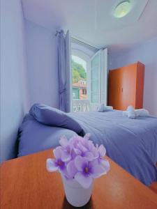 库迪列罗Habitacion privado con baño privado en La Maresía的卧室配有一张桌子和紫色花瓶