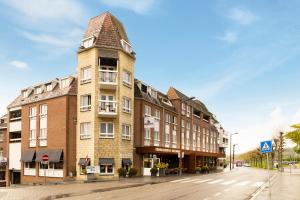 法尔肯堡Dormio Wijnhotel Valkenburg的街道上一座高大的砖砌建筑,塔楼