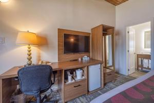 加纳诺克华美达省旅馆的一间卧室配有一张桌子、一台电视和一把椅子