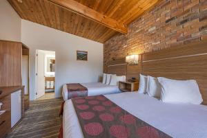 加纳诺克华美达省旅馆的酒店客房带两张床和砖墙